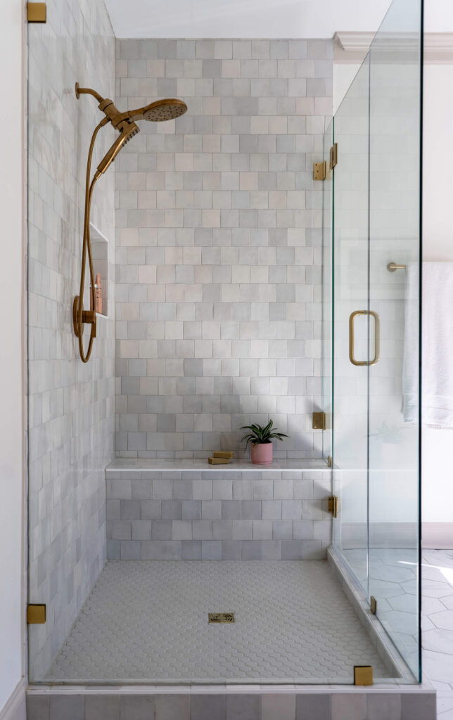 A stand up shower design with gray and white marble tile surround. Design by Holly Thompson Design.