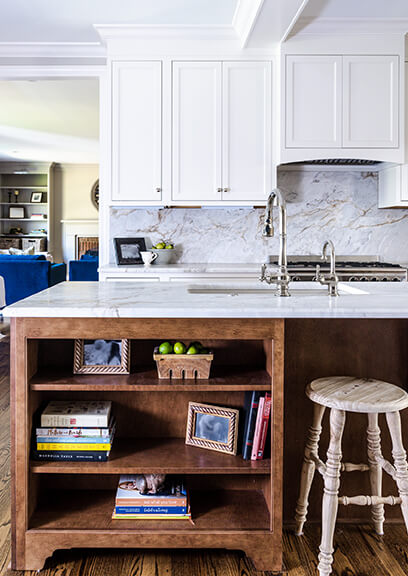 A built-in kitchen island with bookshelves for displaying photographs and cookbooks.