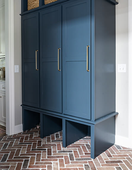 In the adjacent mudroom, custom locker cabinets are in place.