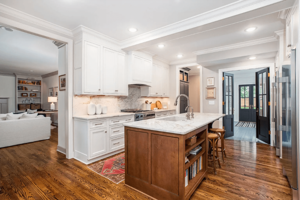 A side view of the kitchen with double French doors leading into the entryway